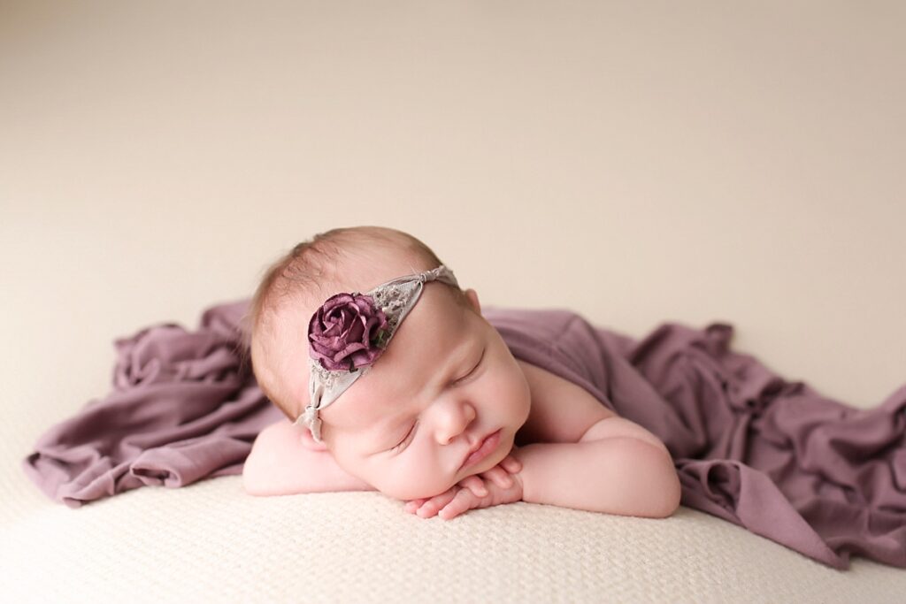 Baby girl sleeping under a purple blanket