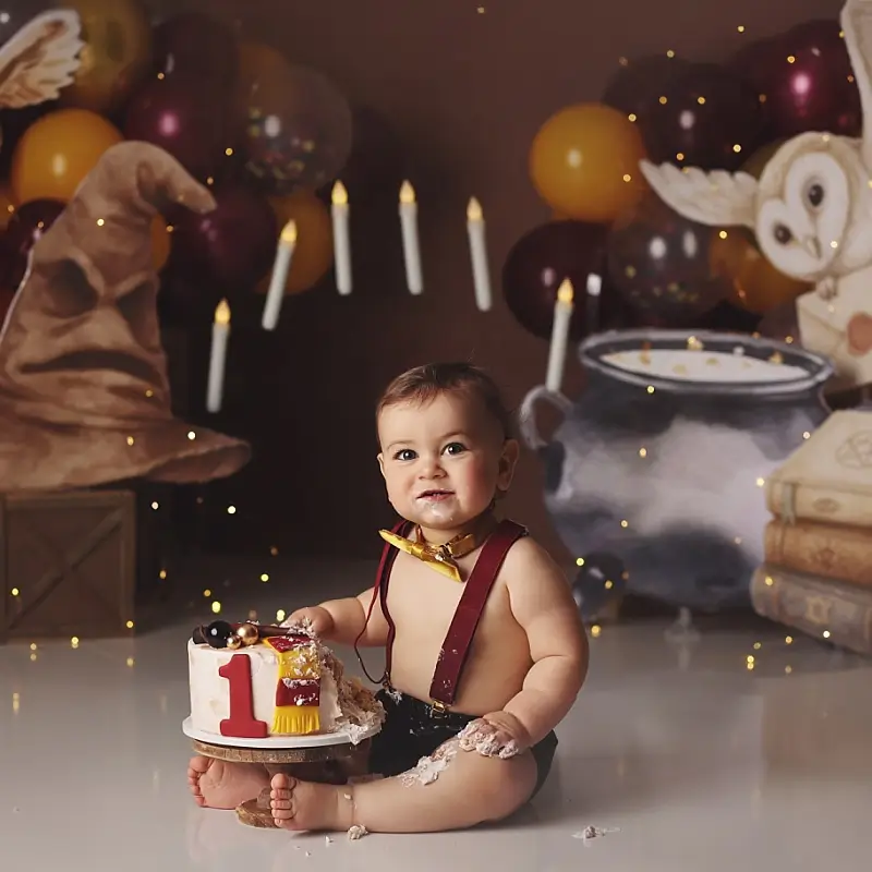 Harry-potter-cake-smash-kansas-city-studio-session Baby boy Harry Potter themed cake smash session with sorting hat, floating candles, owl prop, and first birthday cake