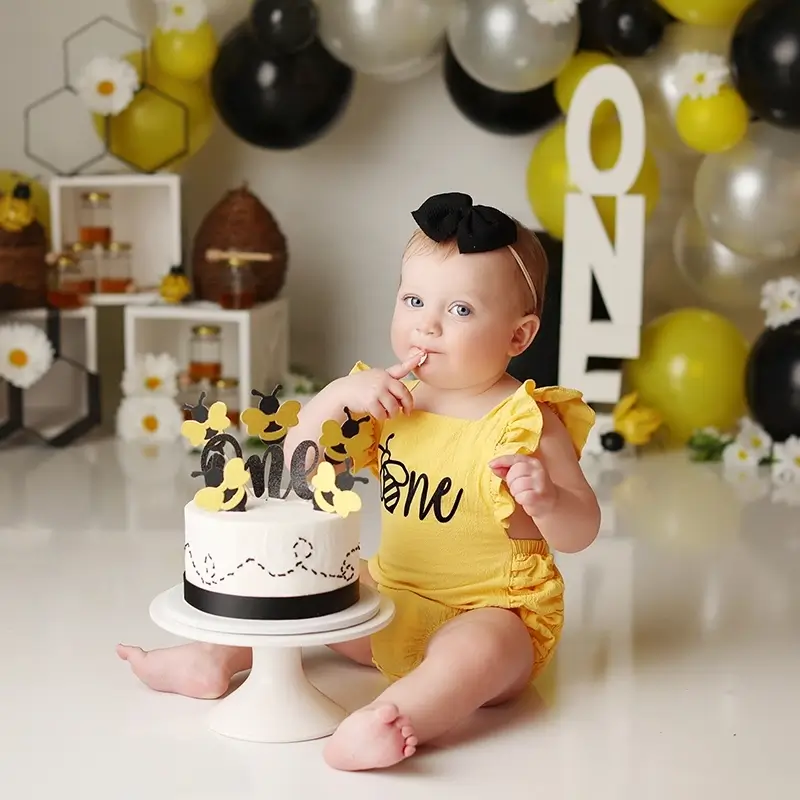 Kansas-city-bumble-bee-theme-cake-smash Baby girl in yellow outfit at first birthday cake smash session, testimonial from Samantha