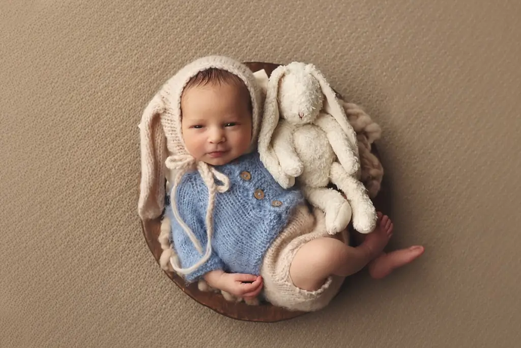 Newborn baby boy dressed in bunny outfit during Kansas City newborn photography session