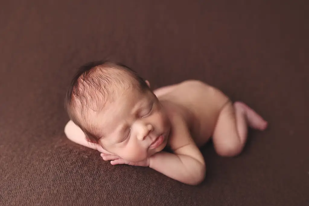 Newborn baby boy posed on soft brown blanket during stress-free newborn photography in Kansas City