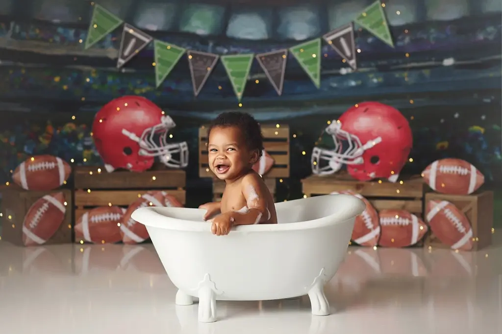 Baby boy splashing in bubble bath after cake smash session in Kansas City