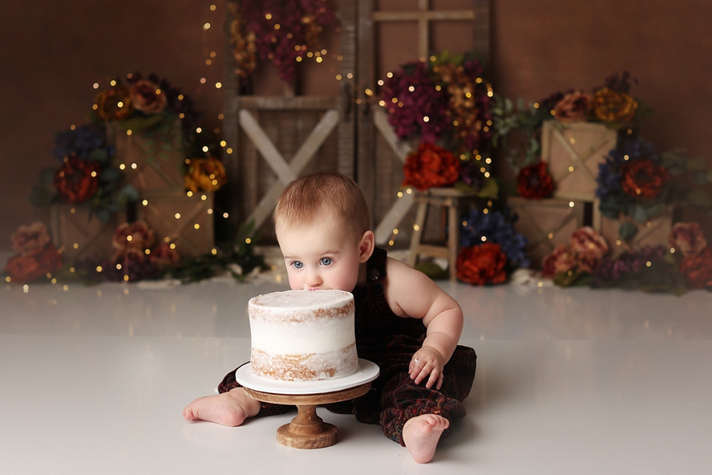 Baby girl face first in cake during fun Kansas City cake smash photography session