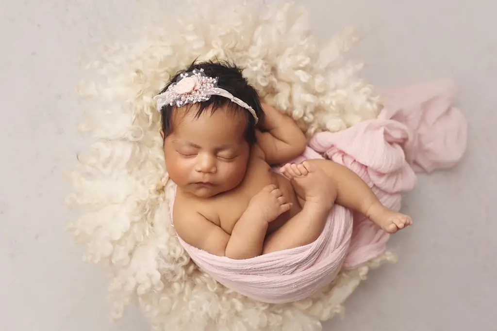 Swaddled newborn baby girl in basket during Kansas City newborn portrait session