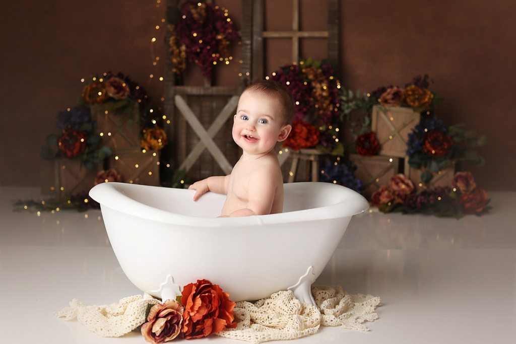 Baby girl in bubble bath splash after cake smash during Kansas City photography session