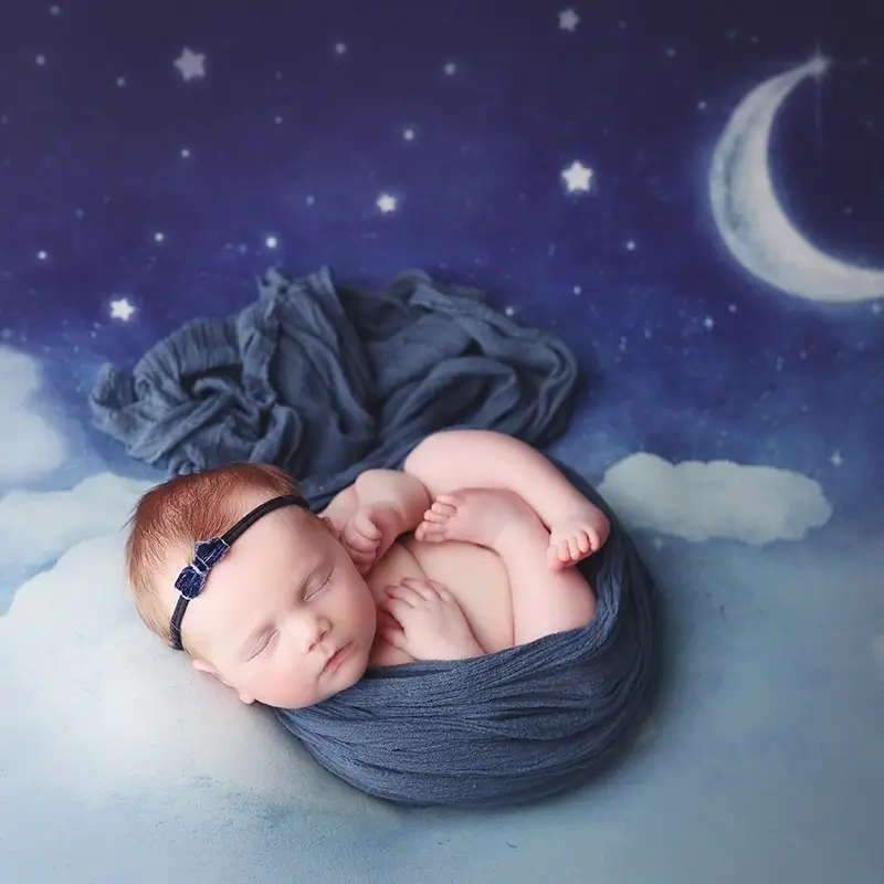 baby-girl-swaddled-in-blue-kansas-city-newborn-session Newborn baby girl posed on dreamy moon and stars backdrop in Kansas City studio, testimonial from Beth