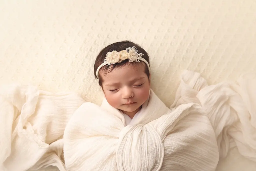 Newborn baby girl sleeping peacefully during Kansas City photography session