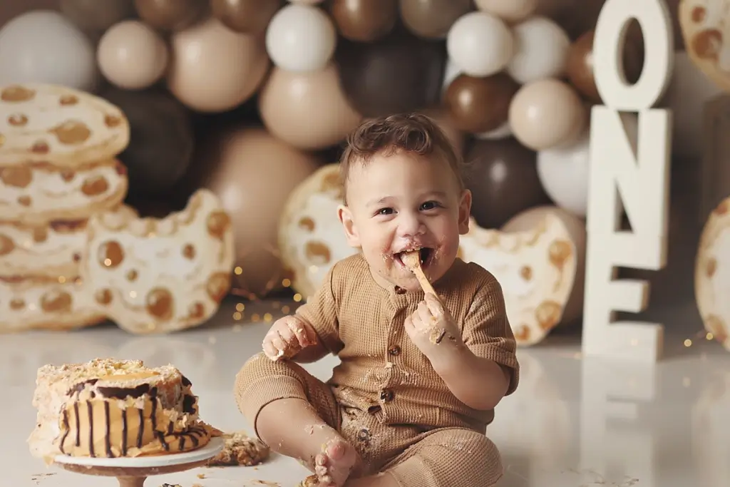 Baby boy celebrating first birthday with chocolate chip cookie cake smash in Kansas City studio
