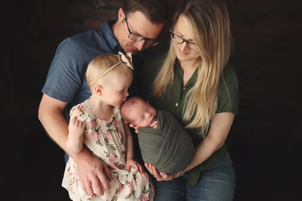 Family of four with newborn baby boy during professional Kansas City newborn photography session