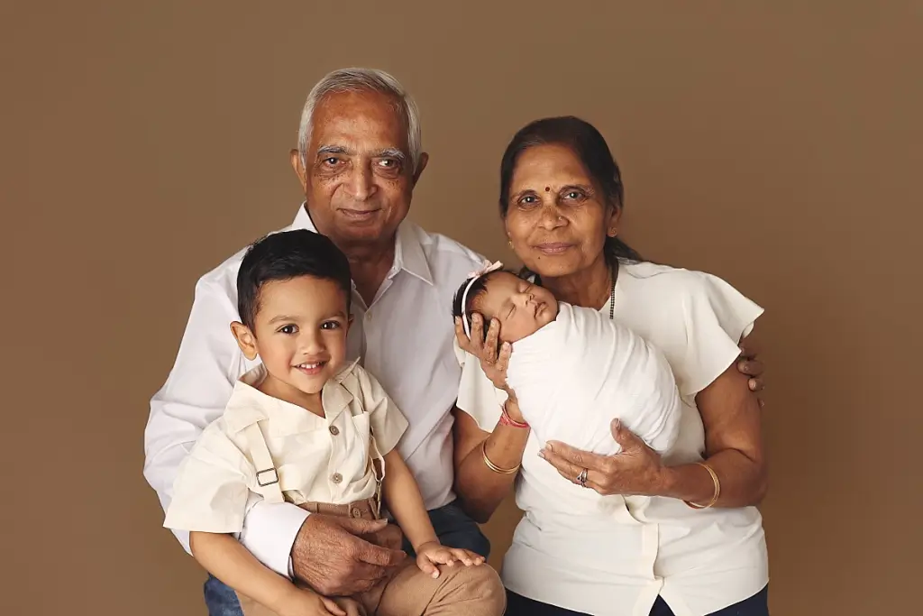 Grandparents with children and newborn baby girl during multi-generational family portrait session in Kansas City