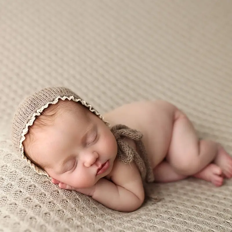 kansas-city-baby-girl-newborn-session-sleeping-baby-in-knit-bonnet Newborn baby girl portrait on cream blanket by Kansas City photographer, testimonial from Franie