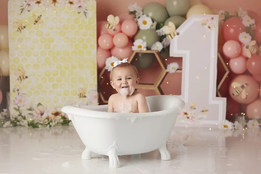 One-year-old girl enjoying bubble bath splash after Kansas City cake smash photography session