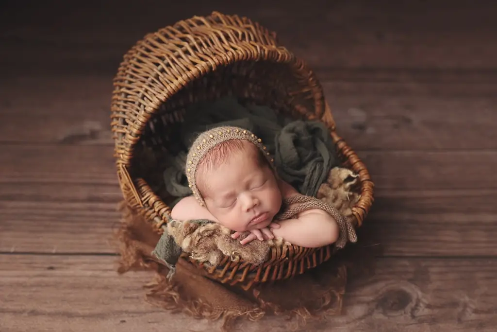 Professional portrait of newborn boy in rustic basket at Anna Marie Photography studio