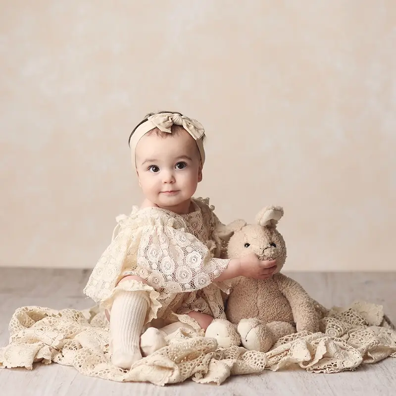 kansas-city-sitter-photo Kansas City sitter photography of baby girl with bow on her head holding a stuffed bunny