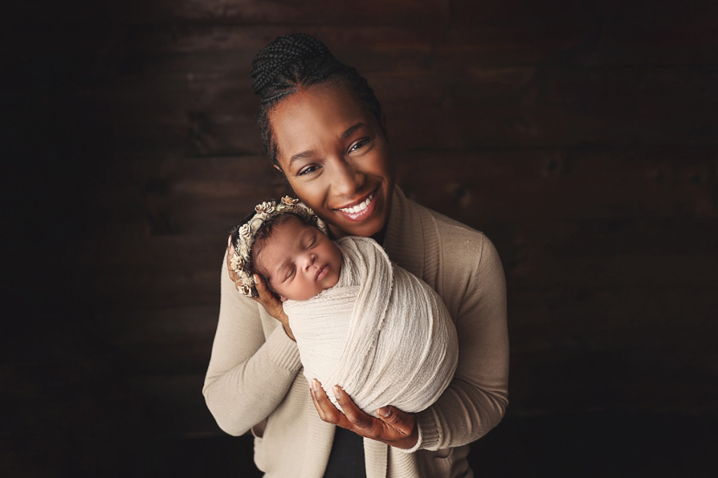 Mother holding newborn baby girl during stress-free newborn photography experience in Kansas City