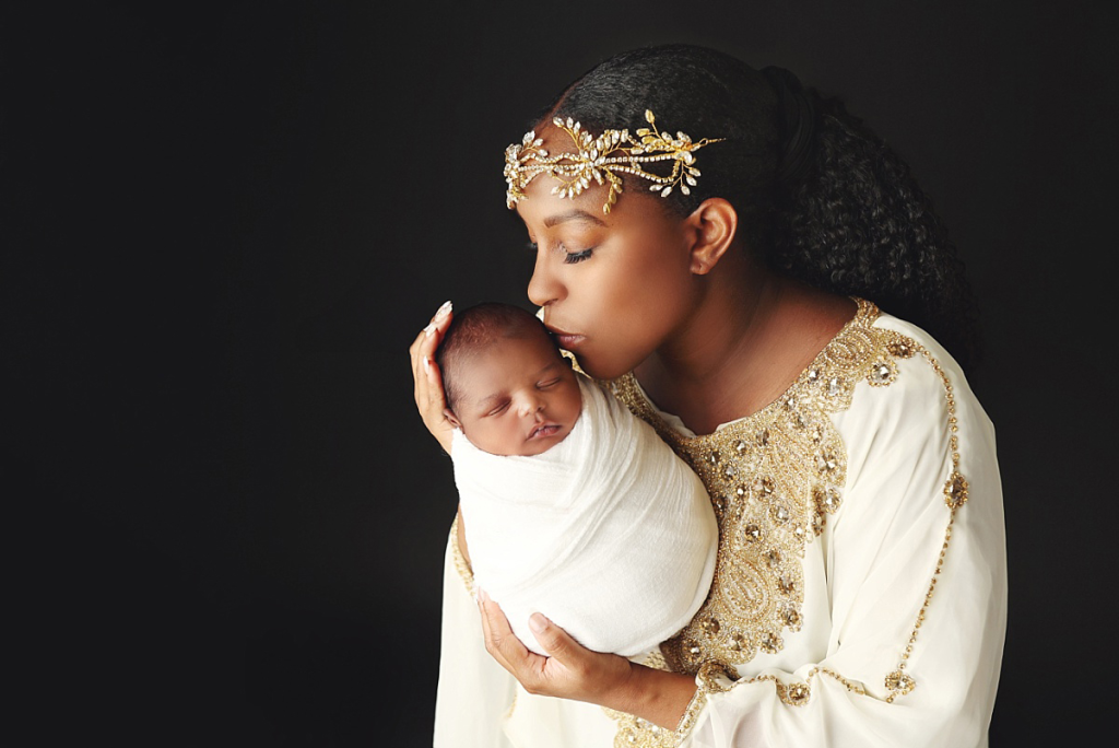 Mother gently holding newborn baby boy during stress-free newborn session in Kansas City