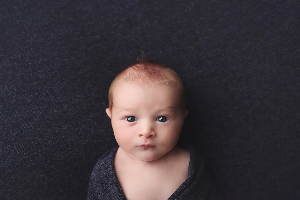 Wide awake newborn baby boy captured in cozy Kansas City newborn session