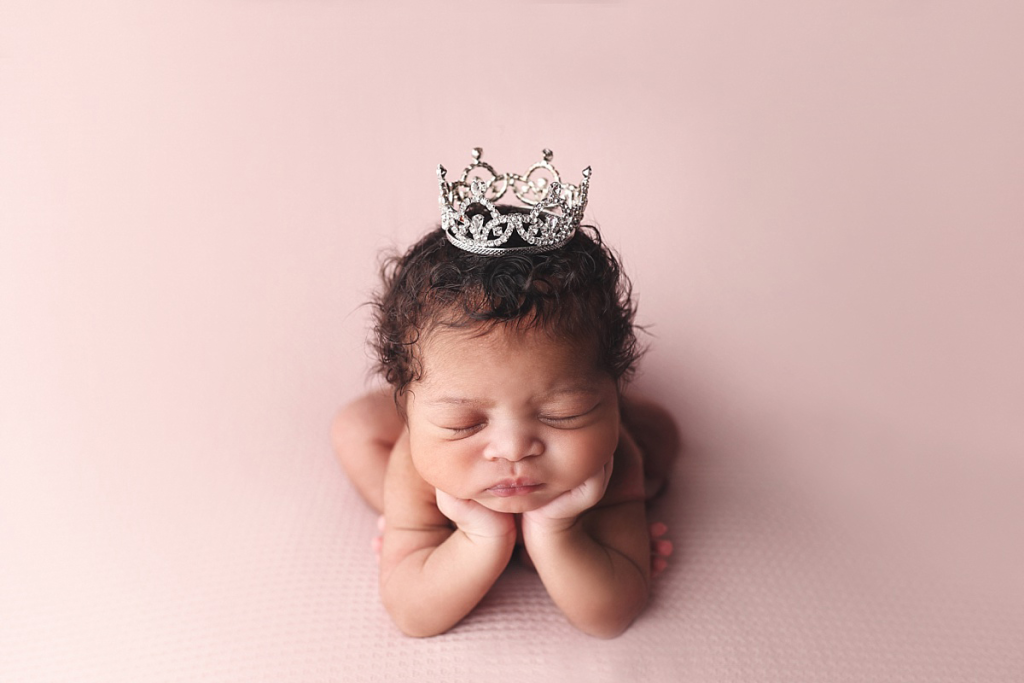 Newborn girl wearing delicate princess crown during professional newborn portraits in Kansas City