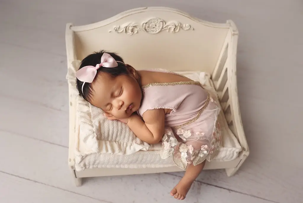 Newborn girl wearing delicate headband during professional portraits in Kansas City