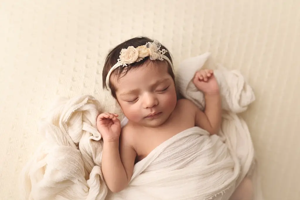 Luxury newborn portrait of baby girl swaddled in soft pink wrap Kansas City