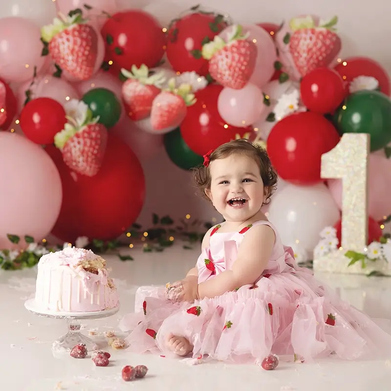 one-year-old-girl-celebrating-her-birthday-kansas-city-studio One year old girl celebrates her birthday at her strawberry themed cake smash in a Kansas City studio photography session