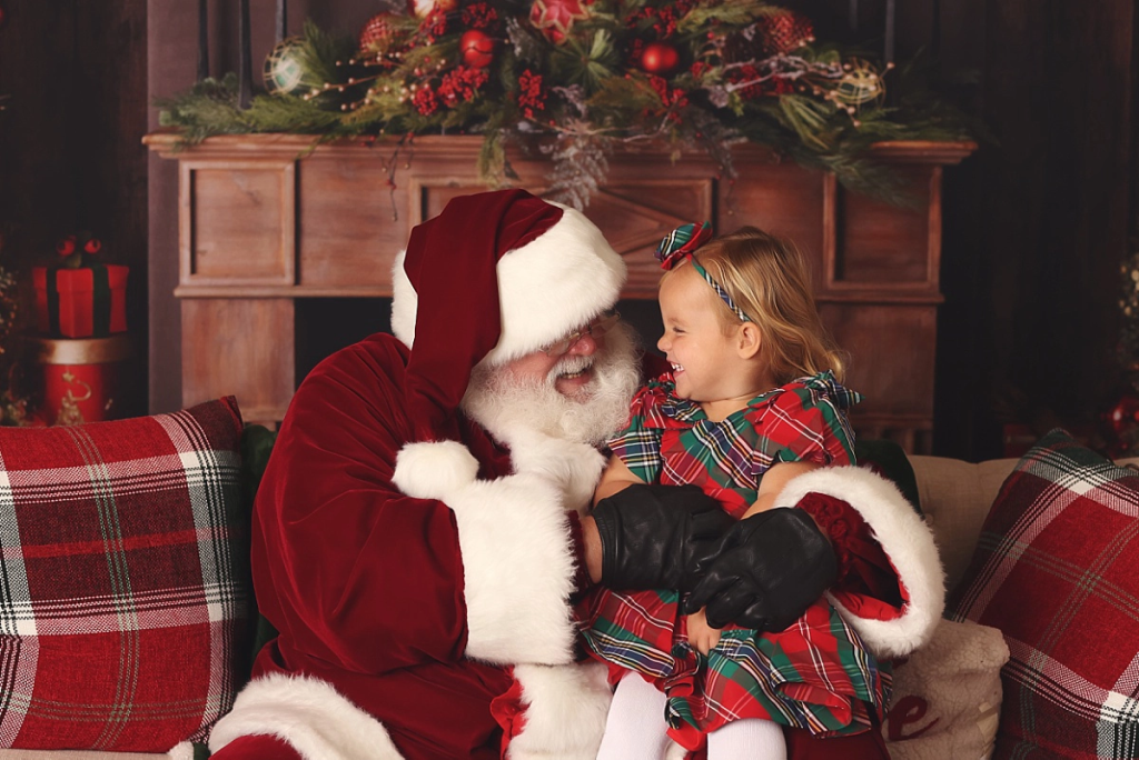 Girl laughing with Santa during holiday mini photography session Kansas City