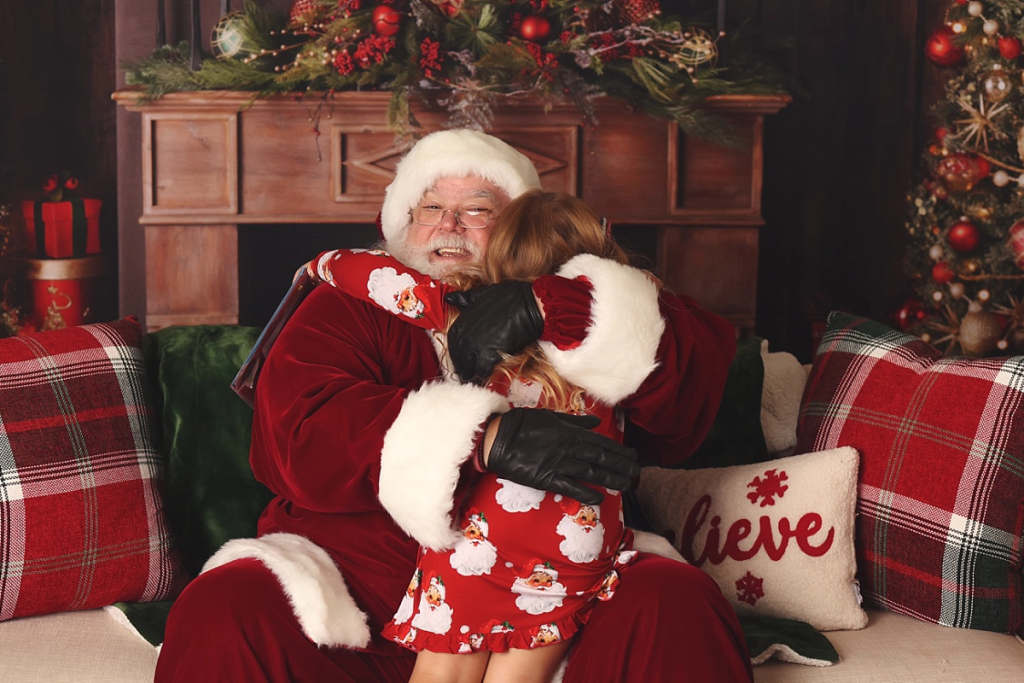 Santa giving a hug to child at Kansas City Santa photography session