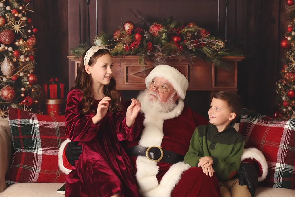 Siblings sharing Christmas wish list with Santa during Kansas City photo shoot
