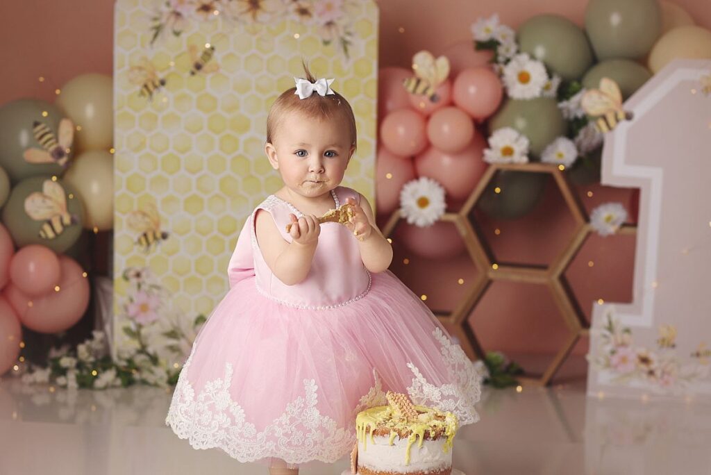 pink and yellow honeybee themed cake smash for little girl in pink dress at kanas city photography studio