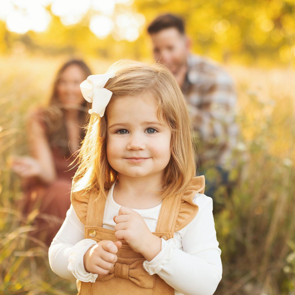 Little girl running toward camera during outdoor family session in Kansas City