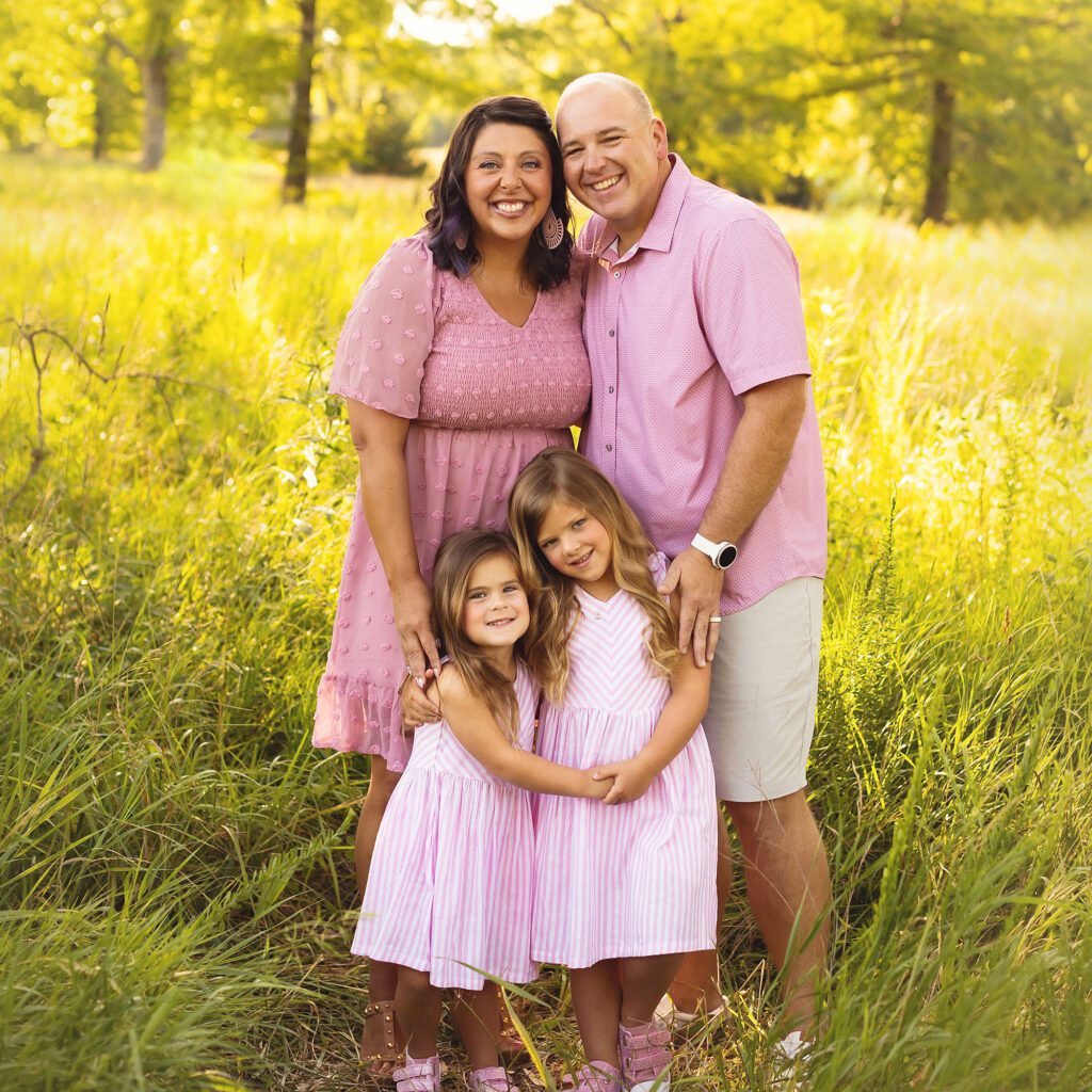 Family wearing pink tones photographed during a summer outdoor session