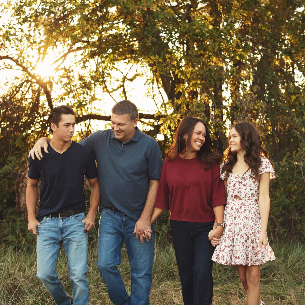 Parents walking with teenage children during fall family session in Kansas City