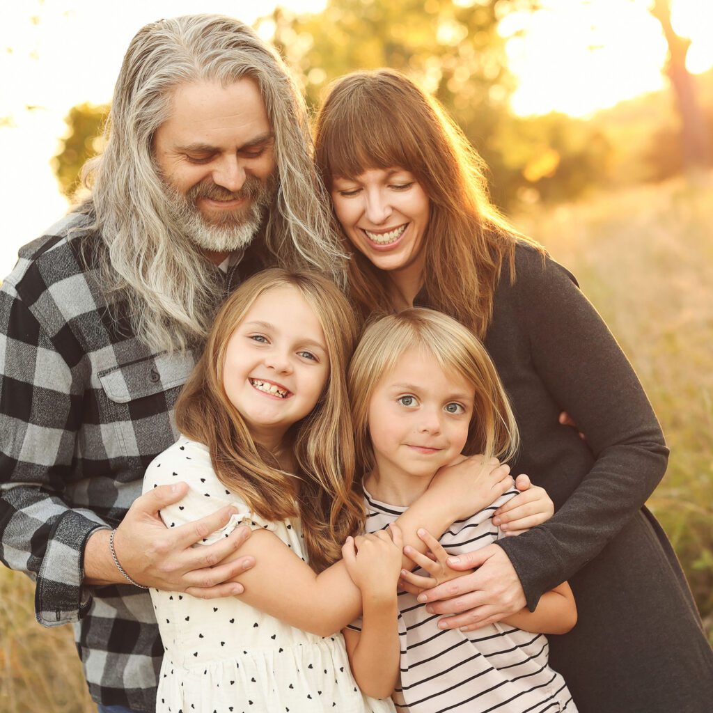 parents with grade school children during backlit fall family session in Kansas City