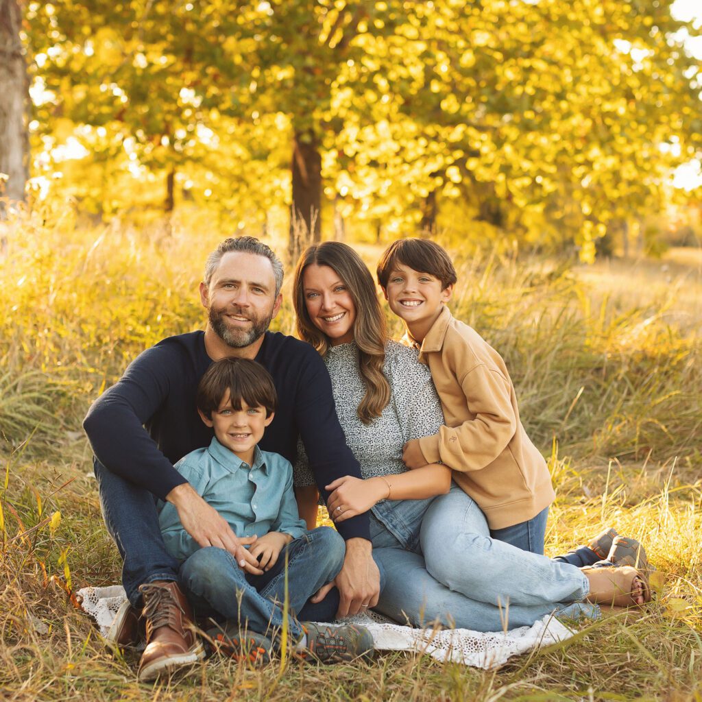 Family snuggled together on the ground during a fall family session in Kansas City