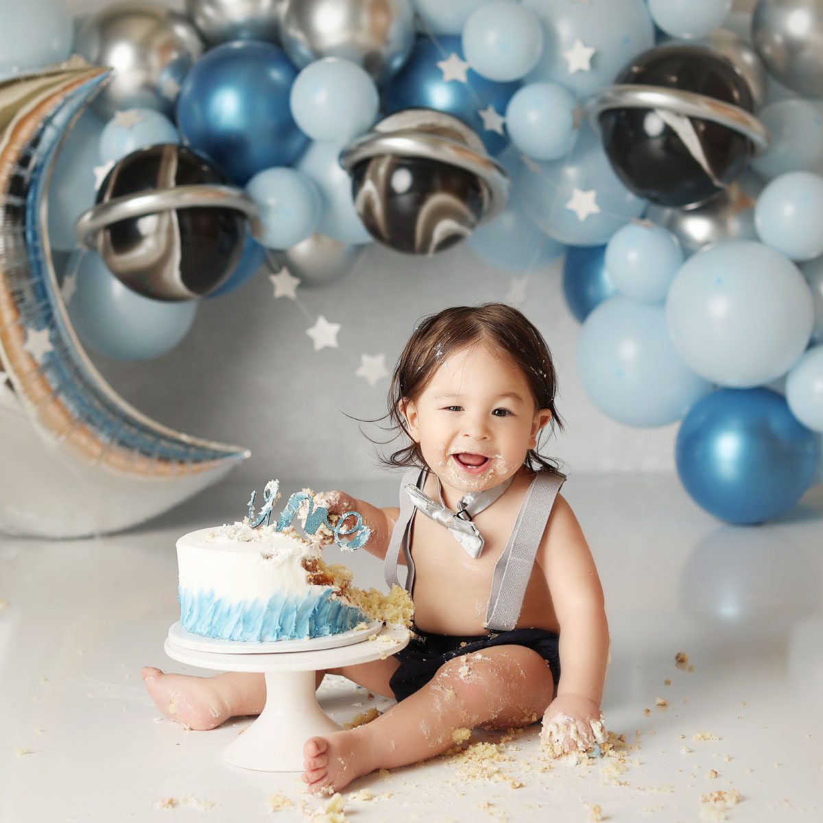 Little boy planets and moon themed cake smash with blue and silver decor in Kansas City