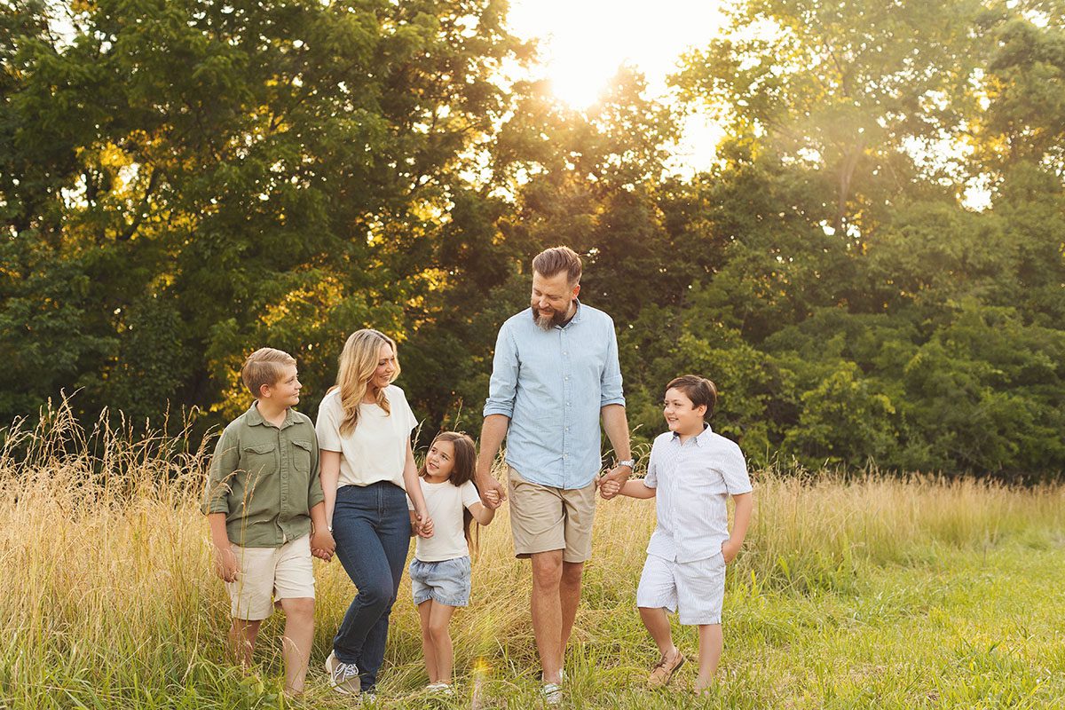 Kansas City family photography outdoor session of family of five walking together at golden hour.