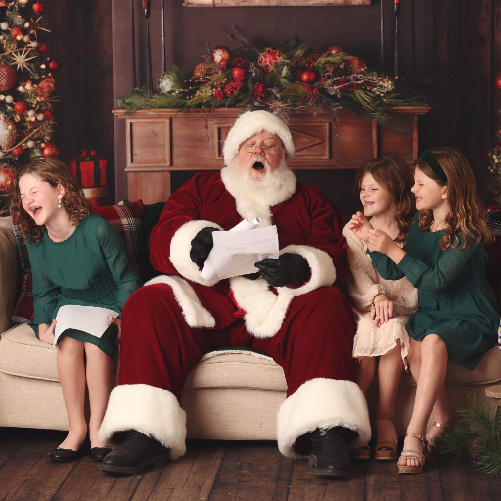 Santa readding a Christmas list surrounded by three sisters laughing
