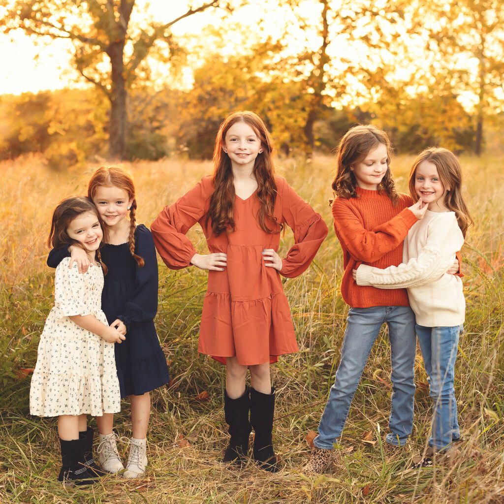Five sisters smiling and laughing during a famll outdoor family session