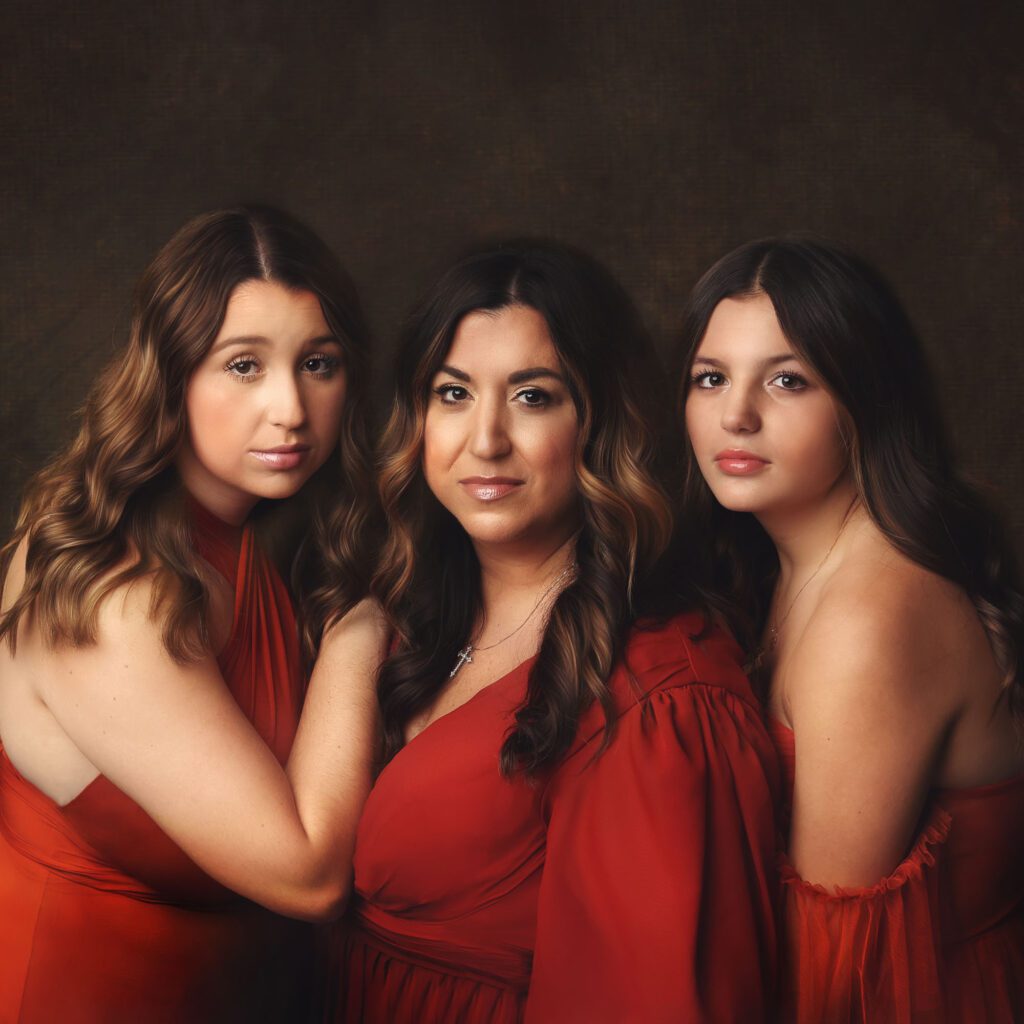 Mother and two daughters wearing rust colored dresses photographed in studio