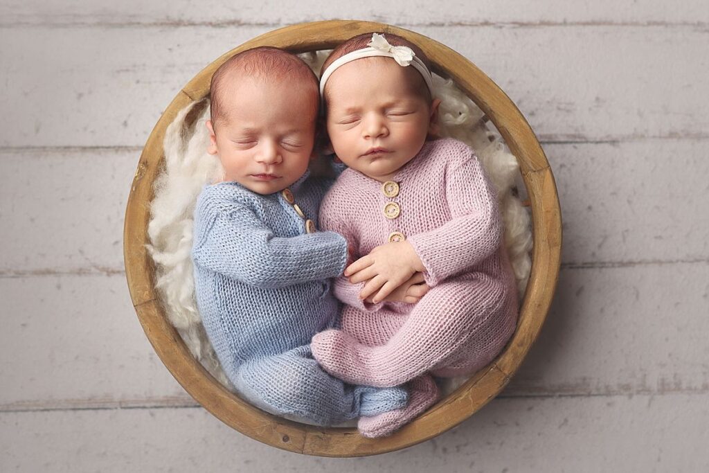 Overhead twin newborn portrait in a basket with neutral knit outfits during a Lee's Summit studio newborn session