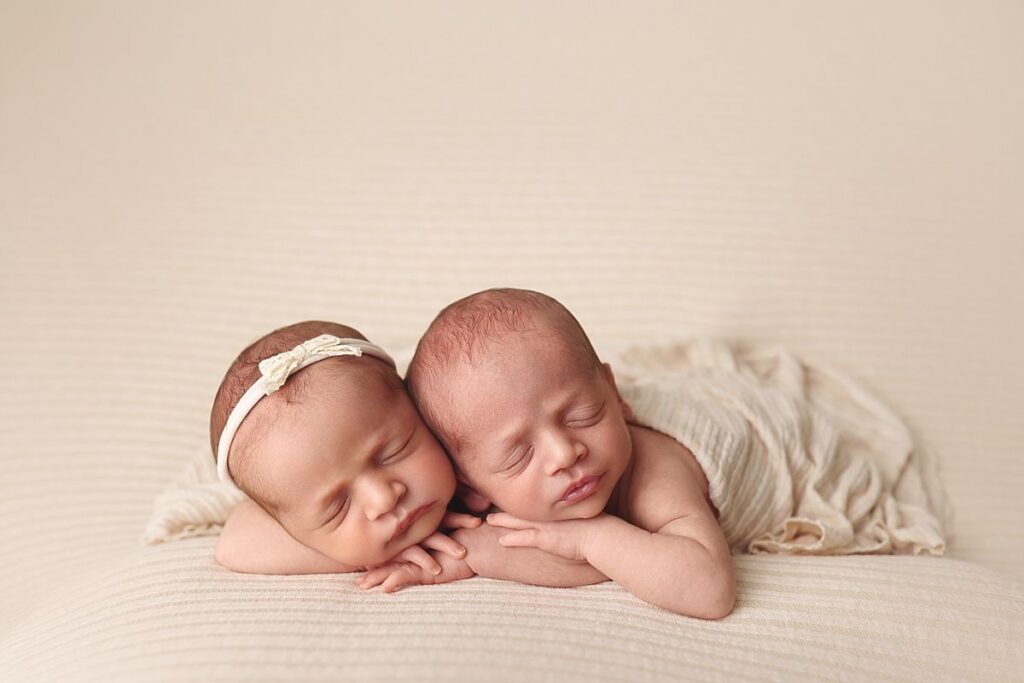 Newborn twins posed together on a neutral cream blanket during a studio twin newborn session near Lee's Summit